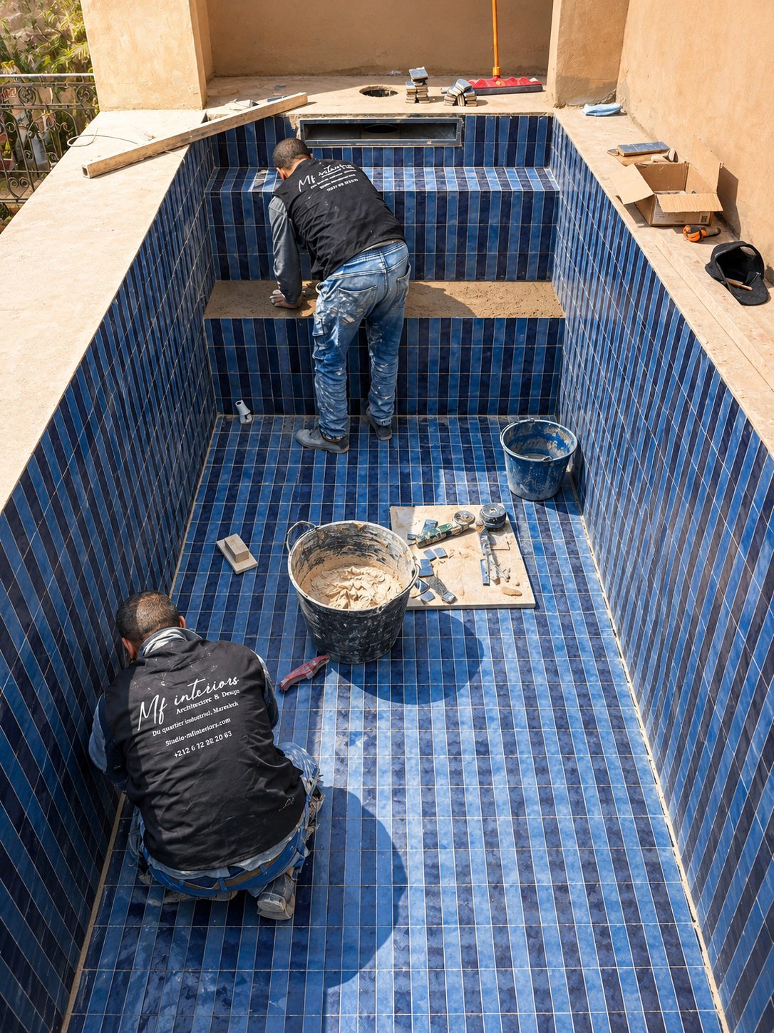 Artisan posant du zellige bleu sur un chantier MF Interiors à Marrakech